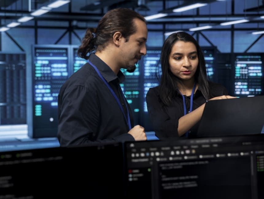 two professionals discussing something in the server room